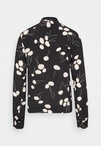 Camicia nera a maniche lunghe con motivo floreale bianco, colletto classico e polsini con bottoni. Tessuto liscio con una forma leggermente aderente.