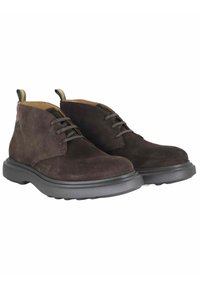 Stivaletti chukka in suede marrone con punta arrotondata, lacci piatti e suola nera in gomma resistente. Dotati di un tirante sul retro.