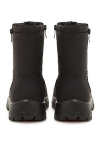 Botas aislantes negras con un material exterior liso, forma redondeada, caña alta y suelas de goma con un patrón de agarre texturizado.