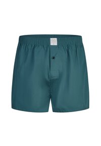 Turquoise herenboxershorts met elastische tailleband en een enkele zwarte knoop op de gulp, gefotografeerd van voren tegen een witte achtergrond.