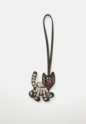 Black and white leather cat-shaped keychain featuring a patterned body, round eyes, a red mouth, and a hanging loop.