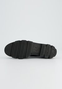 Suola nera di scarpa con un design piatto e segmentato. Presenta scanalature orizzontali e un logo impresso in un'area rettangolare. Texture liscia.