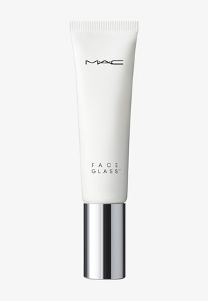 Tube cosmétique blanc avec bouchon argenté étiqueté MAC Face Glass sur un fond clair uni.