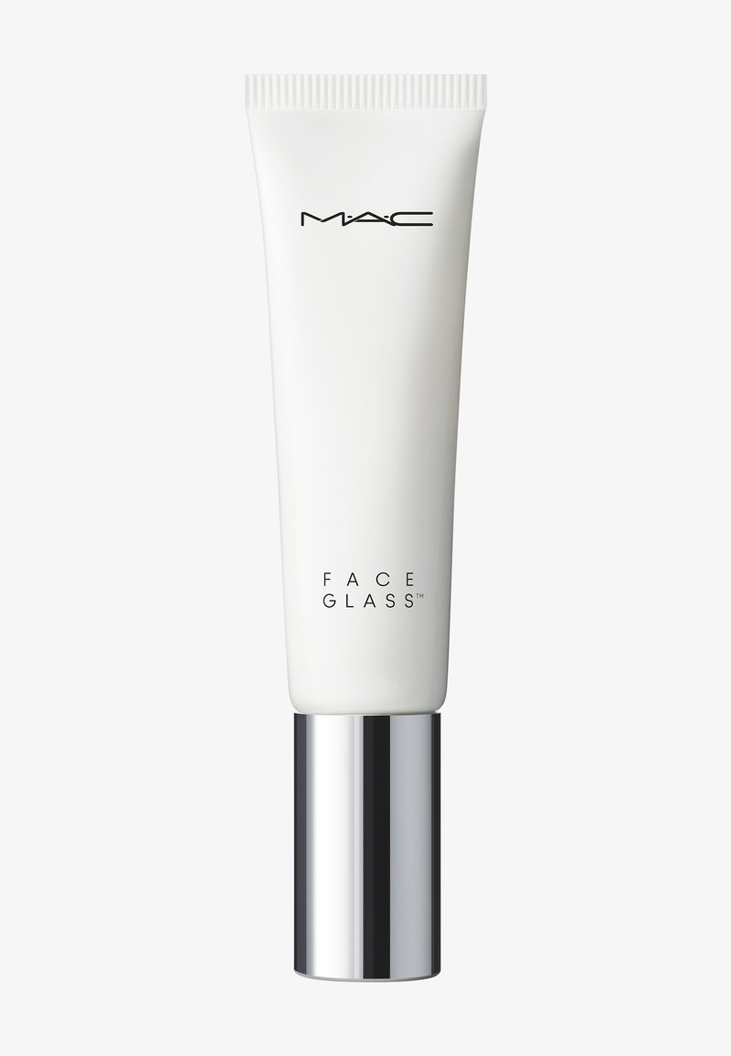 Tube cosmétique blanc avec bouchon argenté étiqueté MAC Face Glass sur un fond clair uni.