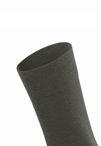 Olivgrüne Crew-Socke mit strukturiertem Strick, abgerundetem oberen Rand und glatter Oberfläche; der Stoff wirkt weich und flexibel, mit minimalen Nähdetails.
