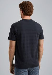 Camiseta de manga corta azul oscuro, hecha de un tejido texturizado con sutiles rayas horizontales, que presenta un cuello redondo y un corte regular.