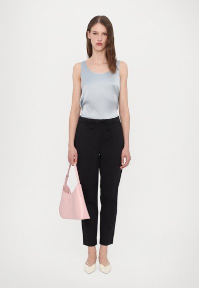 Hele sinine satiintopp, mustad elastsed püksid, roosa käekott ja kreemjad terava ninaga kingad. Lihtne disain, sile tekstuur ja kontrastsed värvid.