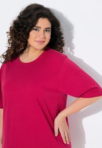 T-shirt fucsia a maniche corte con collo tondo, realizzato in tessuto morbido, caratterizzato da una vestibilità rilassata e dettagli di cucitura minimali.