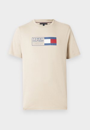 Beige bomull t-skjorte med et rektangulært trykk i blått, hvitt og rødt, med "TOMMY HILFIGER" i midten. Korte ermer.