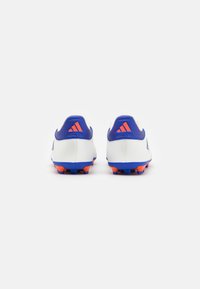 Scarpe da calcio bianche con accenti blu e arancioni, caratterizzate da upper sintetico liscio e tacchetti stampati per una migliore aderenza. Logo a tre strisce visibile.
