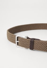 Braided fabric belt in brown with a silver metal buckle and a dark brown leather accent. Textured weave pattern for added detail.