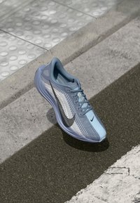 Light blue running shoe with mesh upper, gray accents, and black swoosh logo; features a cushioned sole and rounded toe design.