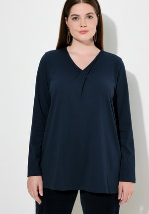 Maglia a maniche lunghe blu navy con scollatura a V e dettagli drappeggiati sul davanti. Realizzata in tessuto morbido, ha una vestibilità rilassata e ampia.