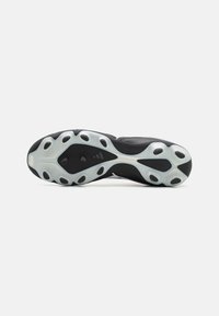 Suela de zapato deportivo negro con una superficie texturizada, que presenta múltiples recortes redondeados y un acento blanco suave alrededor de los bordes.