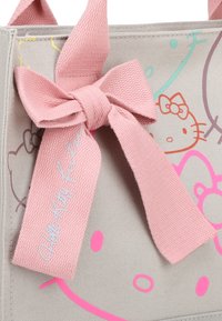 Borsa in tessuto grigia con fiocco e dettagli in nastro rosa chiaro. Presenta grafica colorata e giocosa con motivi e pattern di Hello Kitty.