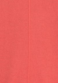 Koraalkleurige geribbelde stof met een zachte textuur, met een verticale naaddetail die over het midden loopt.