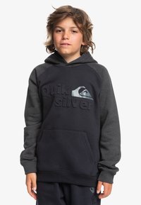 Sudadera oscura de color navy con mangas grises, presenta un logo en 3D de "Quiksilver", bolsillo canguro, puños de canalé y una textura suave.