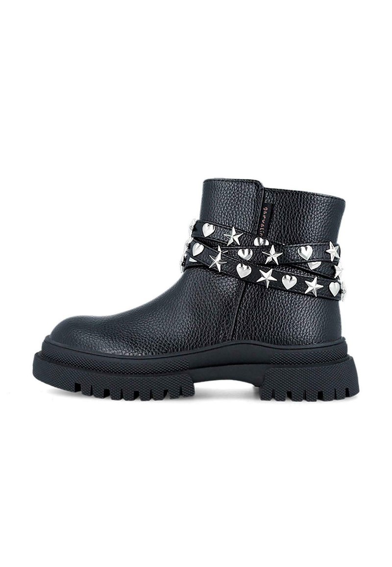 Botas negras hasta el tobillo hechas de cuero texturizado, con tachuelas plateadas de estrellas y corazones en una doble correa y suela gruesa de goma negra.