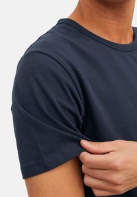 Navyblauwe katoenen t-shirt met korte mouwen, voorzien van een ronde halslijn en een standaard pasvorm; de stof lijkt zacht met een minimale textuur.