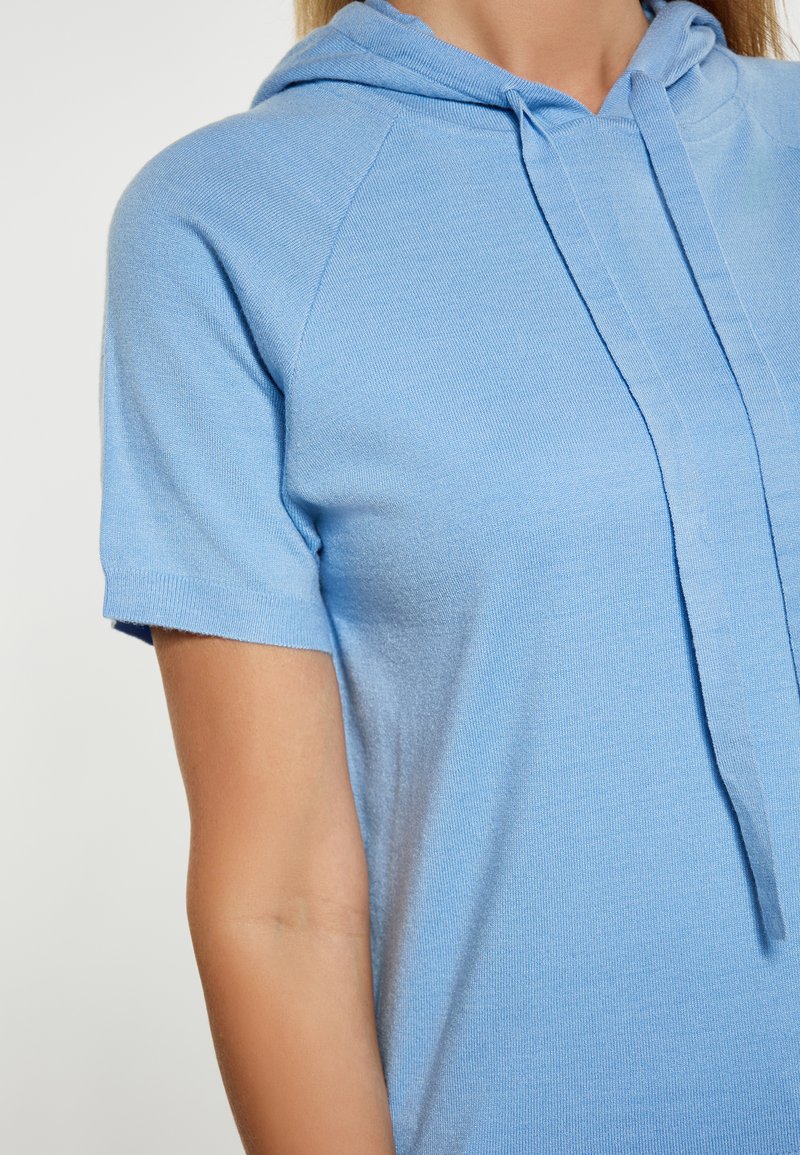 Felpa corta azzurro chiaro a maniche corte realizzata in tessuto morbido, con coulisse al collo e vestibilità comoda. Texture liscia e design informale.