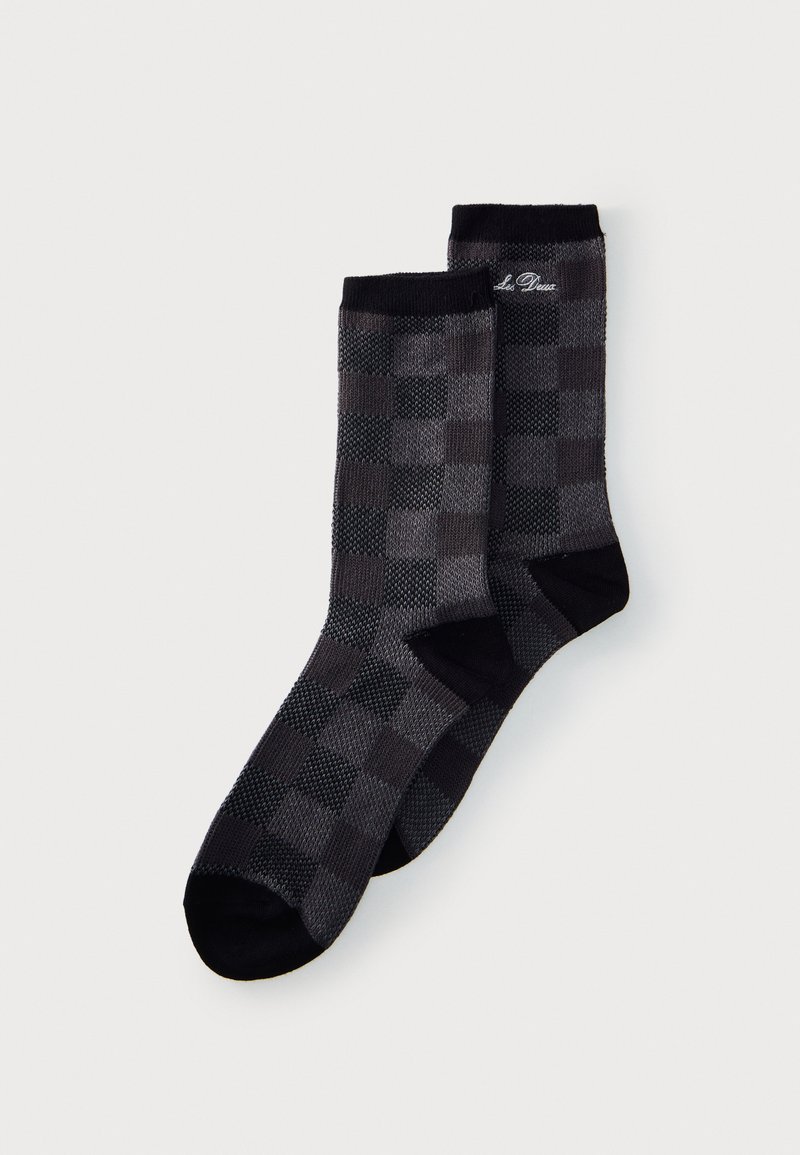 Paire de chaussettes à carreaux gris foncé et noir avec orteils, talons et bord-côtes noirs, et petit texte blanc brodé près du haut.