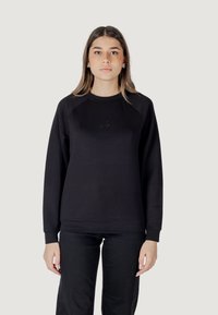 Felpa nera con scollatura a girocollo e maniche raglan, caratterizzata da un branding discreto sul petto, realizzata in un materiale morbido e testurizzato.