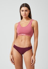 Rosa Baumwoll-Sport-BH mit breiten Trägern und "SNOCKS"-Logo, kombiniert mit burgunderfarbenen Stoffunterhosen. Glatte Textur und enganliegendes Design.