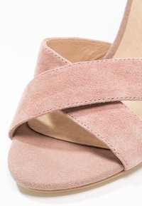 Damernas öppna sandal med korskorsade mockaremmen i dammig rosa och en beige vadderad innersula.