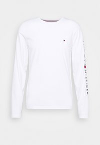 T-shirt bianca a maniche lunghe con scollatura rotonda, caratterizzata da un piccolo logo sul petto e testo stampato lungo la manica in blu navy e rosso.
