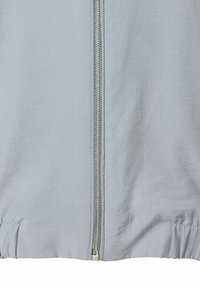 Light gray zip-up jacket made of smooth fabric, featuring a metal zipper and elastic hem at the bottom. Simple design with no patterns.