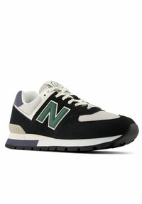 Czarno-biały sneaker New Balance z zielonym logo, cholewką z siateczki, zamszowymi nakładkami, białymi sznurówkami i czarną gumową podeszwą, widoczny z lewej strony.
