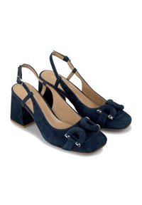 Granatowe zamszowe szpilki na odkrytej pięcie z kwadratowym noskiem, masywnym obcasem oraz dekoracyjną kokardą z elementami w srebrnym kolorze.