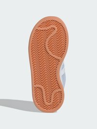 Potplat cipele od narančaste gume s teksturiranim valovitim uzorkom. Sivi gornji materijal je vidljiv, ističući detalje dizajna i izrade.