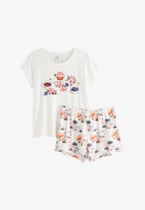 Bela majica s kratkimi rokavi iz pižame z barvitimi potiski hrane in cvetja; ujemajoče kratke hlače imajo podoben dizajn z vzorci vrtnic in sladic.