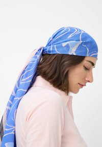 Blå og pink silkeslørf med et flydende mønster, bundet bagpå, hængende blødt omkring halsen. Glat tekstur og let design.