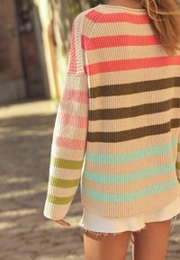 Striped knit sweater with wide sleeves. Features pink, green, and blue stripes on a beige background. Textured ribbed material, rounded hem.