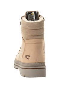 Beige Wildlederstiefelette mit gepolstertem Kragen, Reißverschluss und strukturiertem grauem Gummisohle. Mit dezentem Logodetail an der Seite.
