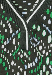 Textiel met een zwarte achtergrond met een patroon van groene, witte en lichtblauwe stippen; heeft een textuur V-halslijn met contrasterende bies.