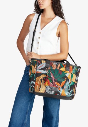 Borsa a tracolla ricamata colorata con motivi di foglie tropicali, base in tessuto nero e dettagli in pelle. Include un accessorio a nappina decorativa.
