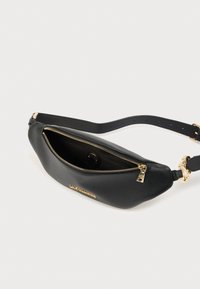 Μαύρο δερμάτινο τσαντάκι μέσης με υφή, χρυσαφένιο φερμουάρ και αφαιρούμενο ιμάντα. Διαθέτει έναν κύριο θάλαμο.