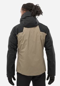 Veste imperméable avec une partie supérieure noire et une partie inférieure beige, dotée d'un col haut et d'une capuche. Tissu texturé et poignets réglables.
