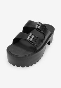 Sandali platform neri con due cinturini regolabili, soletta texturizzata e una suola spessa e robusta per una buona aderenza. Realizzati in materiale sintetico.