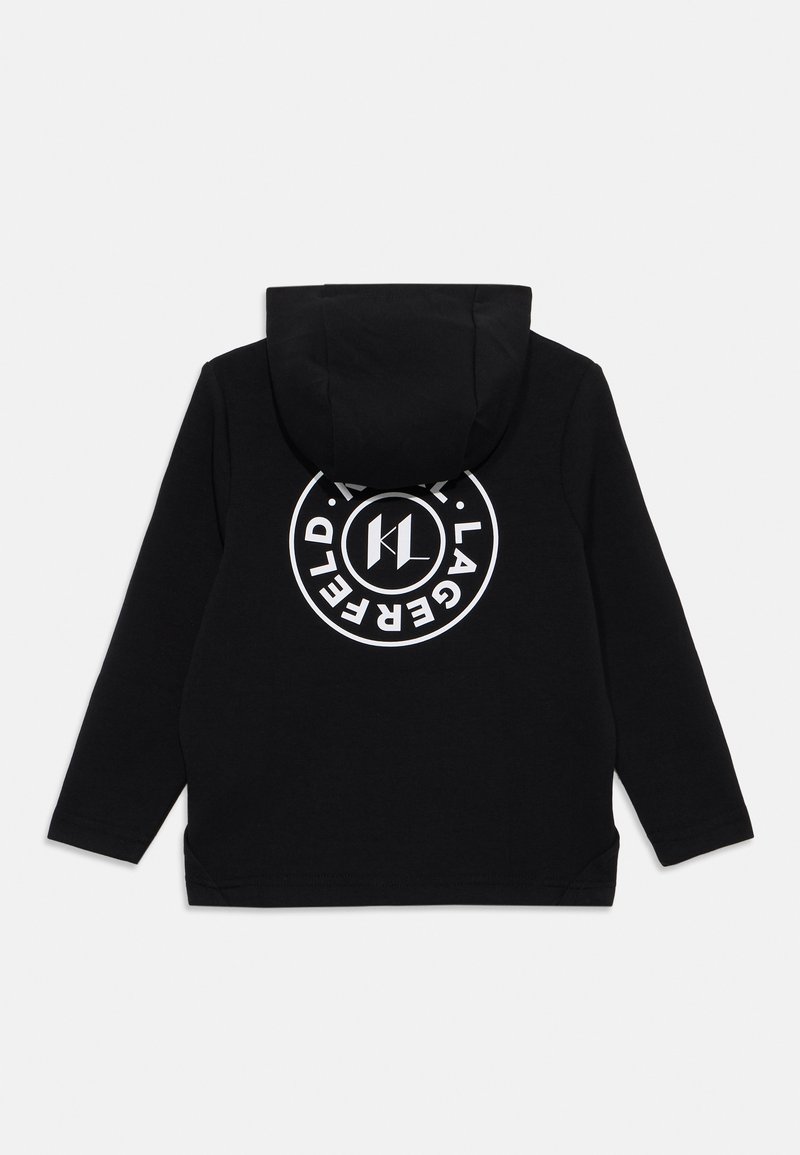Sweatshirt à capuche noir en coton avec des manches longues. Présente un grand logo circulaire blanc dans le dos, indiquant l'identité de marque.