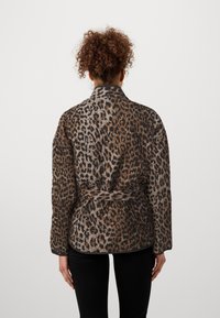 Kabát s leopardím vzorem v hnědých a černých odstínech, vyrobený z měkké tkaniny, s páskem v pase, šálovým límcem a dlouhými rukávy.