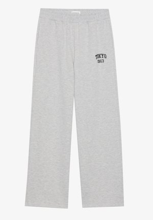 Light gray sweatpants with an elastic waistband, featuring a black "TOKYO 1963" logo on the left side. Soft fabric, wide-leg design.