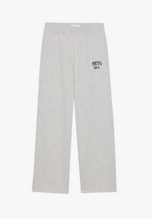 Light gray sweatpants with an elastic waistband, featuring a black "TOKYO 1963" logo on the left side. Soft fabric, wide-leg design.