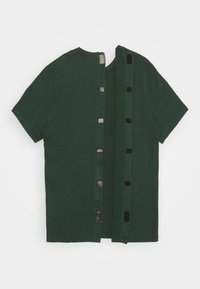 Zelené tričko s krátkým rukávem, které se vyznačuje jedinečným otevřeným designem na zádech s patentkami a hladkým bavlněným textilním materiálem.