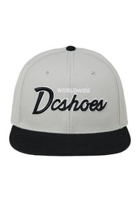 Cappello snapback grigio con visiera nera. Presenta la scritta "WORLDWIDE" in bianco sopra "Dcshoes" ricamata in corsivo nero. Tessuto liscio, design strutturato.