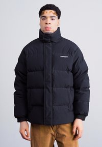 Schwarze Pufferjacke mit hohem Kragen, gestepptem Design und Frontreißverschluss. Inklusive zwei seitlichen Taschen und gerippten Bündchen.
