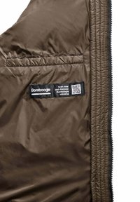 Bruine, gewatteerde jas met een linker zak, een label met QR-code en een rits aan de rechterrand. Glad, lichtgewicht materiaal.